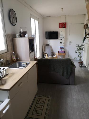 una pequeña cocina con fregadero y nevera. en F2 en centre-ville Chevreuse, en Chevreuse