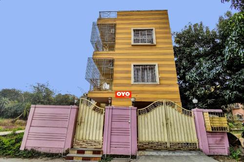 une maison jaune avec des portes roses et un portail dans l'établissement Flagship Crown Tower, à Kolkata