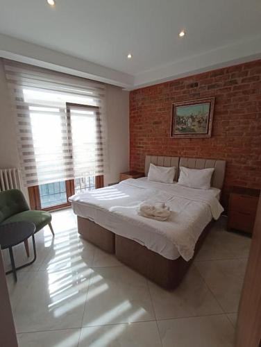 1 dormitorio con 1 cama grande y pared de ladrillo en Elmas en Estambul