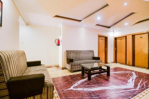 ein Wohnzimmer mit 2 Sofas und einem Couchtisch in der Unterkunft Super Capital O Hotel All Seasons in Jamshedpur