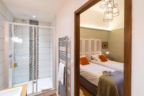 a mirror in a bedroom with two beds and a shower at Coté Remparts in Amboise
