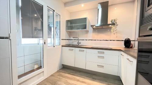 a kitchen with white cabinets and a sink and a window at Palmar - 3 Habitaciones, cerca del Hospital Arrixaca in Murcia
