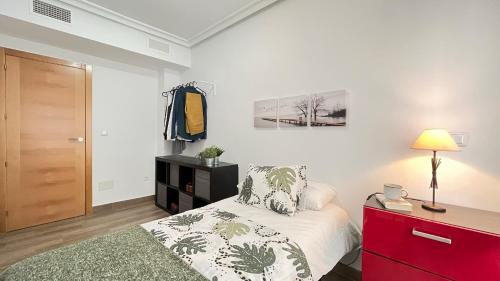 a bedroom with a bed and a dresser with a lamp at Palmar - 3 Habitaciones, cerca del Hospital Arrixaca in Murcia