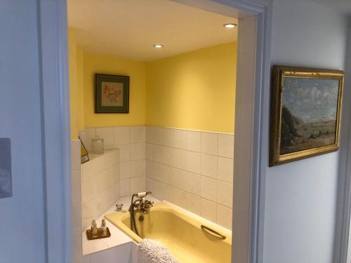 een gele badkamer met een bad en een wastafel bij Charming 2-Bed Apartment in Waterloo Liverpool in Liverpool