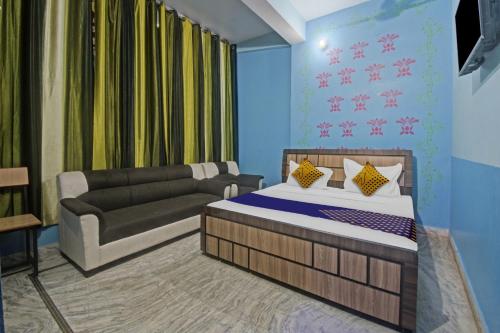 SPOT ON Hotel Rj14 في جايبور: غرفة معيشة مع سرير وأريكة