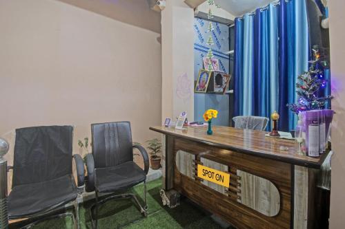 Cette chambre comprend deux chaises, un bureau et un arbre de Noël. dans l'établissement SPOT ON Hotel Rj14, à Jaipur