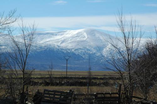 a snow covered mountain in the distance with two benches at Casa Rural Reposo de Afanes in Muñogalindo