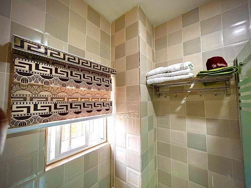 a bathroom with a shower curtain and a window at The Moonshine Residence-Royal in Nnewi