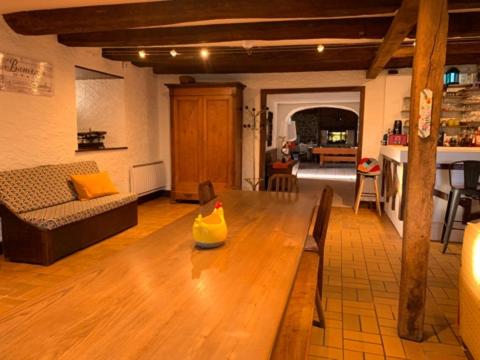 ein Wohnzimmer mit einem Holztisch und einem Sofa in der Unterkunft Logis du lac à Madic in Madic
