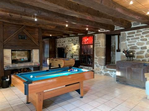 einen Billardtisch in einem Zimmer mit einer Steinmauer in der Unterkunft Logis du lac à Madic in Madic