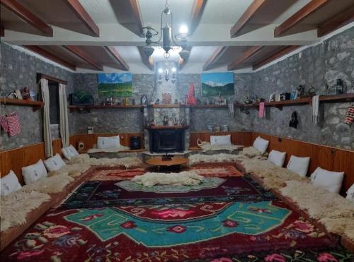 een woonkamer met een groot tapijt op de vloer bij Guest House Korabi in Ceren