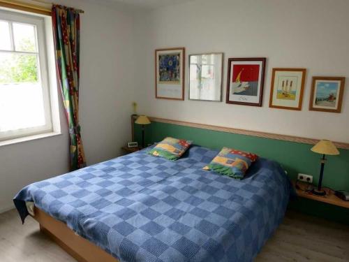 a bedroom with a blue checkered bed with two pillows at Villa Granitz - Ferienwohnung Rechtern in Göhren