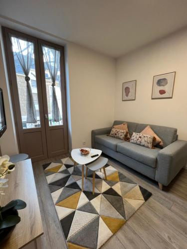 - un salon avec un canapé et une table dans l'établissement Bel T2 refait à neuf climatisé centre, à Brive-la-Gaillarde