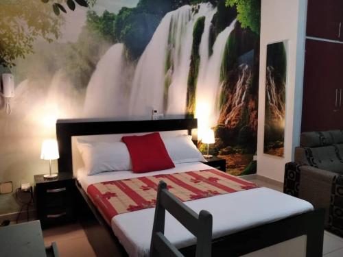 a bedroom with a bed with a waterfall mural on the wall at Agreable Studio Meuble in Abidjan