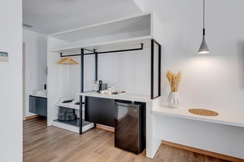 a kitchen with white walls and a black and white counter at Marion Suite in Ermoupoli