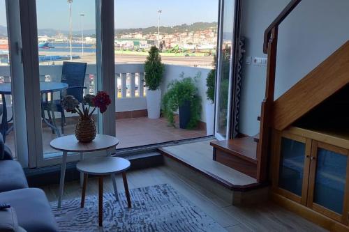 a living room with a balcony with a view of the ocean at Ático Almuiña. in Marín