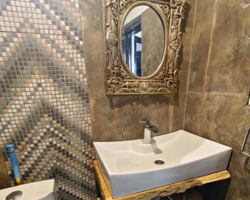 een badkamer met een wastafel en een spiegel aan de muur bij 2 Bed Chalet - Yasam Cloud Nine And a Half Hunza in Baltit
