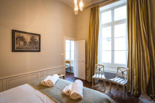 a bedroom with towels on a bed with a window at Coté Remparts in Amboise