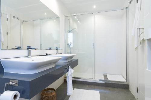 マルベーリャにあるTerrazas de Cabopinoのバスルーム(洗面台2台、ガラス張りのシャワー付)