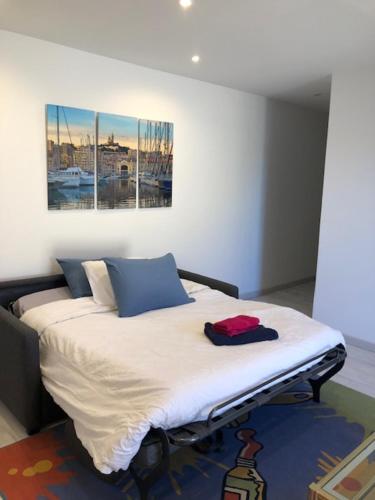 um quarto com uma cama com um quadro na parede em Marseille bleue em Marselha