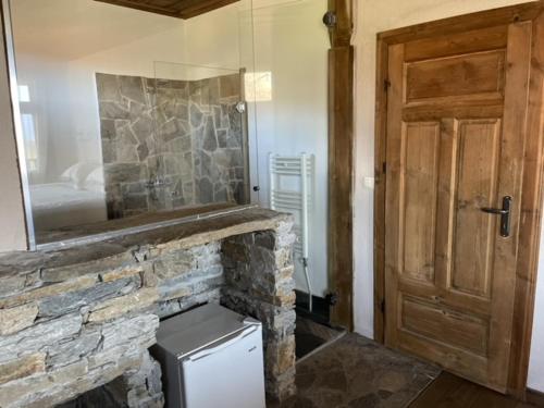 a room with a stone counter and a door and a room with a refrigerator at Leshten Guest Homes in Leshten