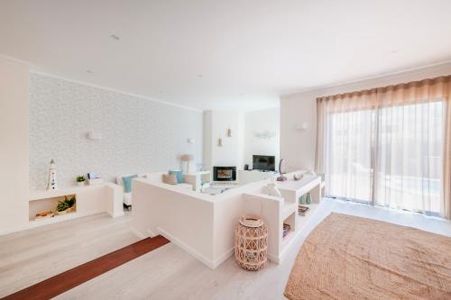 Habitación blanca con escritorio y ventana en Lilies Villa - BlueSea en Albufeira
