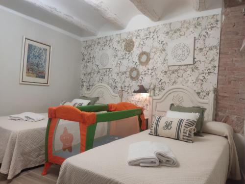 a bedroom with two beds and a wall with wallpaper at El Géiser de Pozuelo in Pozuelo de Aragón