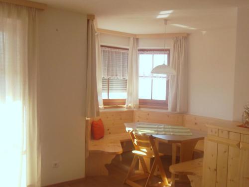 une cuisine avec une table et des chaises ainsi qu'une fenêtre dans l'établissement Parleitnerhof Ferienwohnung Morgenrot, à Rio di Pusteria