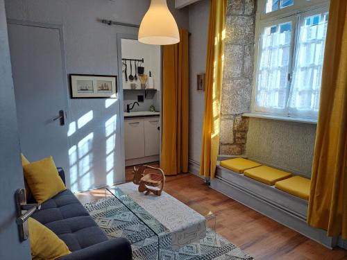 un salon avec un canapé et une fenêtre dans l'établissement TY MA GOURDADOU, à Saint-Pol-de-Léon