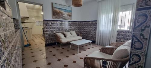 uma sala de estar com um sofá, cadeiras e uma mesa em La Casa del Moral em Isla del Moral