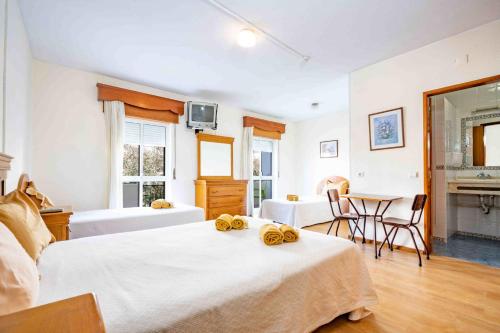 1 dormitorio con 2 camas, mesa y sillas en Residencial Capri by Umbral, en Albufeira