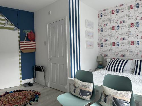 a bedroom with a bed and two chairs at Coastal Joy - Room 1 in Newbiggin-by-the-Sea