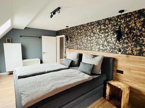 a bedroom with a bed and a wall with floral wallpaper at Ferienhaus Rost in Volkach