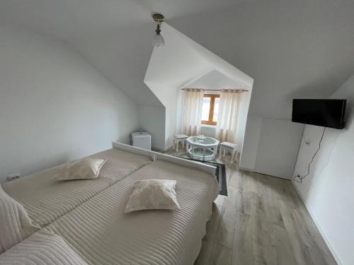 Pecineaga的住宿－Casa Laura，一间白色卧室,配有床和电视