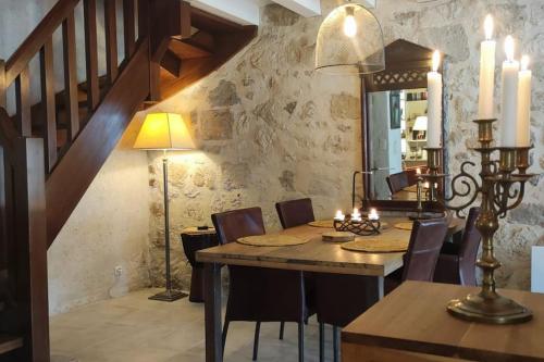 une salle à manger avec une table et des chaises et un escalier dans l'établissement Sous les arcades de Fourcès-Jolie maison médiévale, à Fourcès