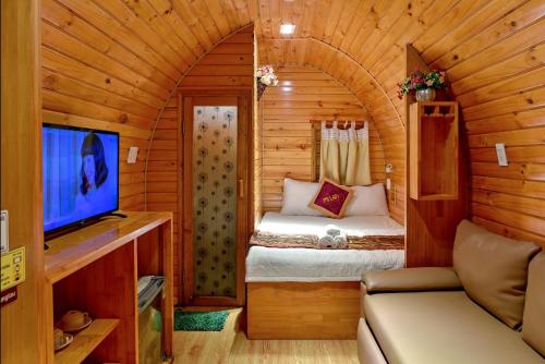 a small room with a bed in a wooden cabin at Mi Lan Boutique Resort in Vung Tau