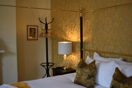 a bedroom with a bed and a lamp on a table at Carlton House - Spacious 4 Bed Victorian townhouse in Harrogate