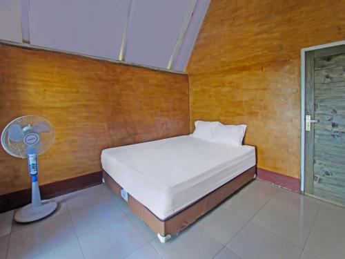 een kleine slaapkamer met een bed en een ventilator bij OYO 92419 Rejeng Homestay Near Kerta Gangga Waterfall in Luk