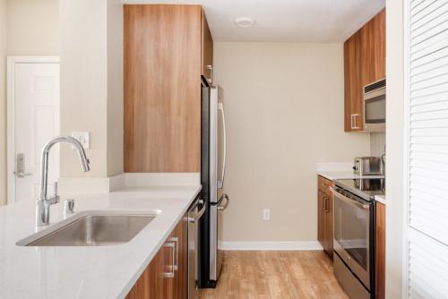 a kitchen with a stainless steel refrigerator and wooden cabinets at Walnut Creek 1BR w BBQ Gym WD nr BART SFO-987 in Pleasant Hill