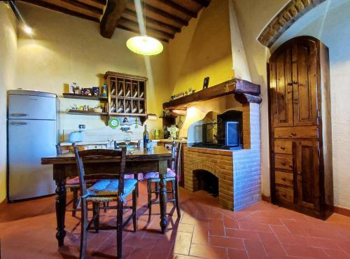 Casa Matteo San Gimignano Apartments في سان جيمنيانو: مطبخ مع طاولة وثلاجة وموقد