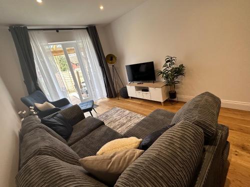 a living room with a couch and a tv at Beautiful house on the River Itchen in Winchester