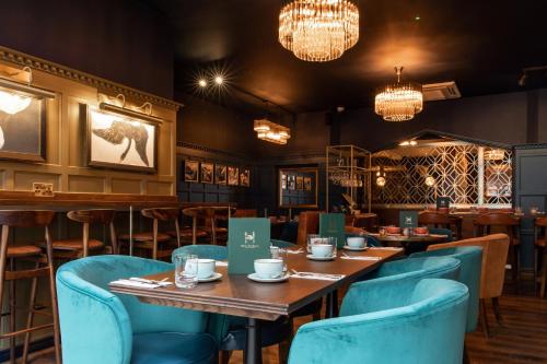 um restaurante com mesas, cadeiras e lustres em Hort's Townhouse em Bristol