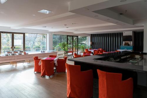 a dining room with red chairs and a bar at Hotel Grand in Sarajevo