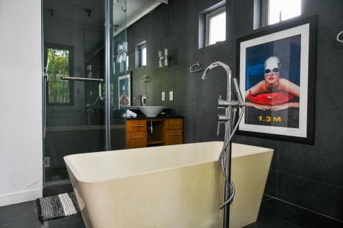 a bathroom with a tub and a picture on the wall at Villa Horizon by Dream Escapes, Beachfront Villa in Pointe aux Cannoniers