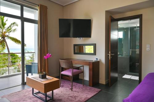 a living room with a desk and a table at Villa Horizon by Dream Escapes, Beachfront Villa in Pointe aux Cannoniers