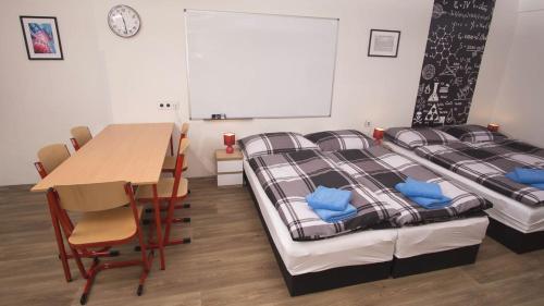 a room with two beds and a table and chairs at School Apartment - Your Unique Place in Prague by metro Vyšehrad in Prague
