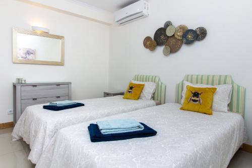 2 camas con toallas en un dormitorio en Bay View Modern Apartment, en Albufeira