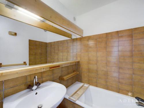 une salle de bain avec un lavabo et un miroir dans l'établissement Studio Cabine 6 Pers. Exposé Sud-Ouest, Centre Station, Proche Commerces et Remontées Mécaniques - FR-1-398-502, à La Rosière