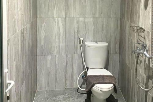 a bathroom with a toilet and a shower at Urbanview Hotel Brodam's Pematang Siantar by RedDoorz in Pematangsiantar