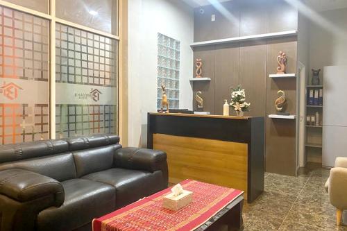 a living room with a leather couch and a table at Urbanview Hotel Brodam's Pematang Siantar by RedDoorz in Pematangsiantar